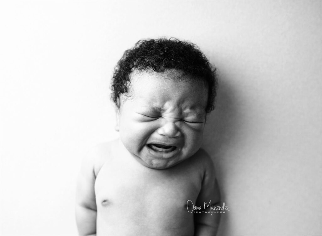Baby crying newborn portrait in black and white.