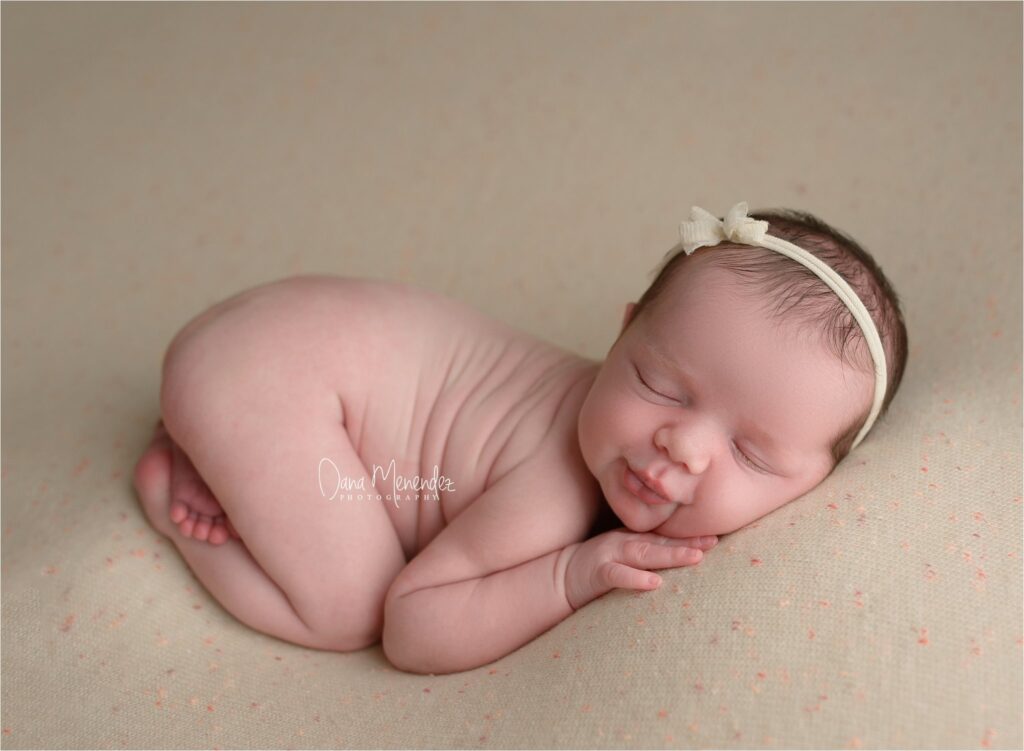 Adorable newborn girl sleeping peacefully on a soft blanket.