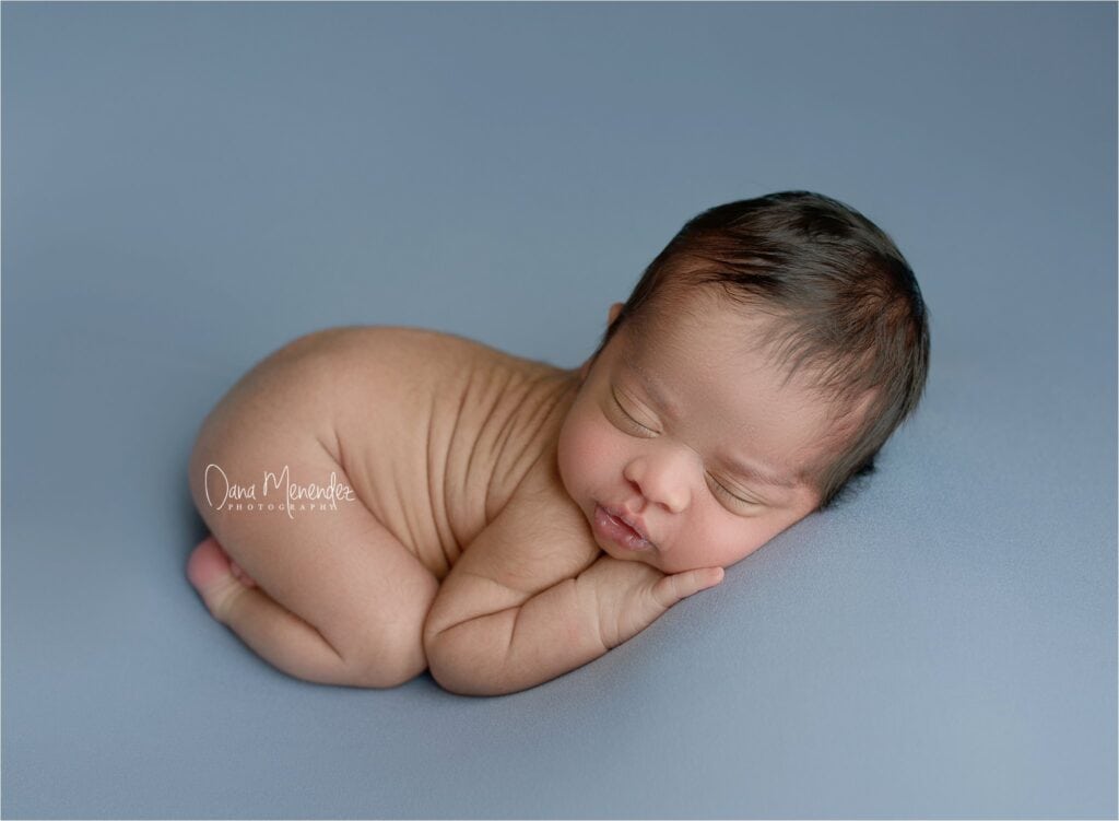 Baby sleeping peacefully on a soft blue background.
