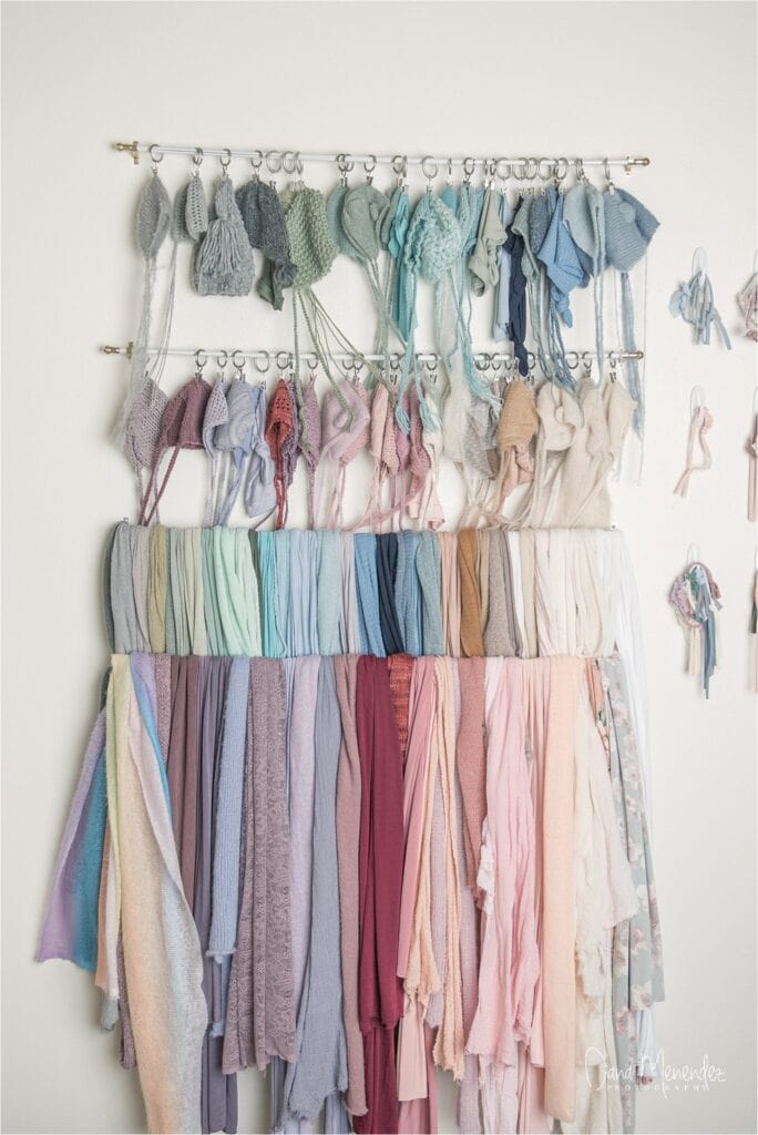 Baby blankets and wraps in pastel colors hanging on a wall display.