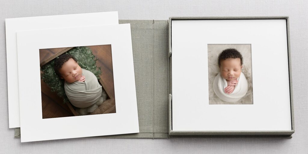 Adorable newborn baby wrapped in a blanket, lying in a photo frame.