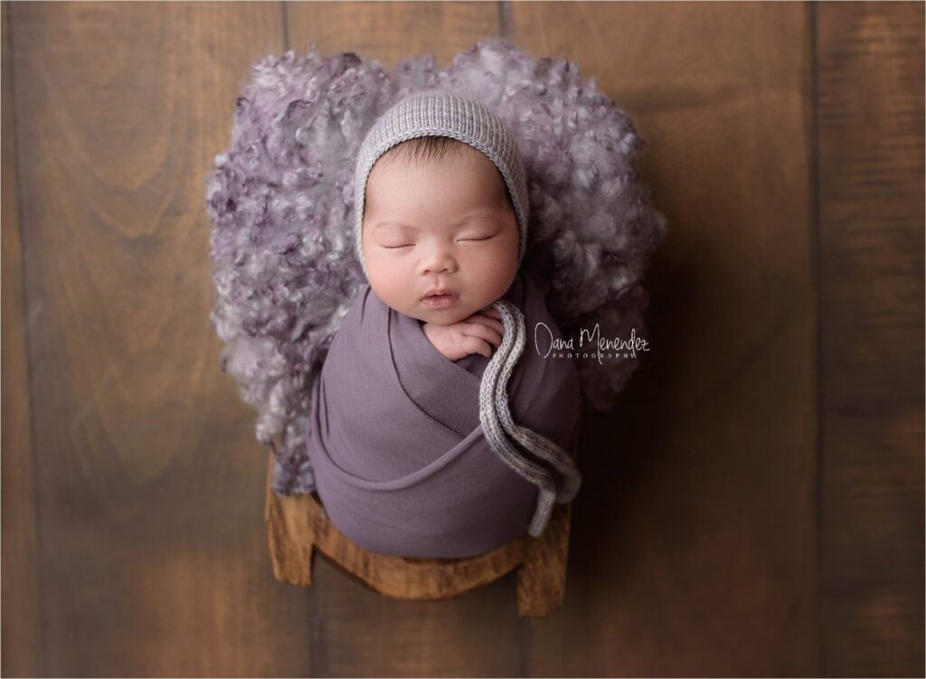 Adorable newborn baby wrapped in a cozy blanket with a knit hat.
