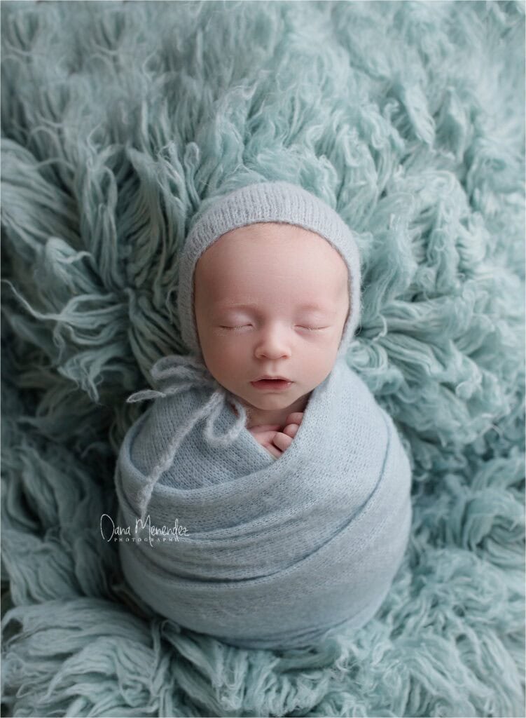 Adorable newborn baby Parker wrapped in a cozy blanket, sleeping peacefully.