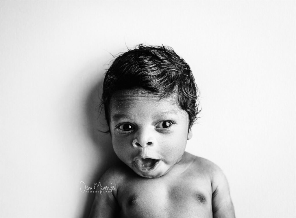 Baby boy with curious expression, black and white portrait.
