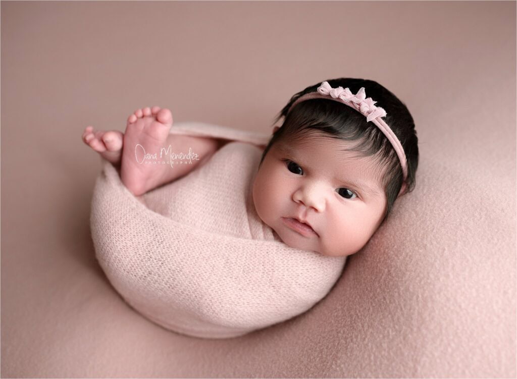 Baby Isobella wrapped in a soft blanket, resting peacefully during her newborn session in Okotoks, A.