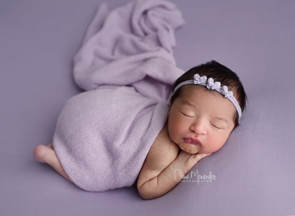 Adorable newborn girl sleeping peacefully on soft blanket.