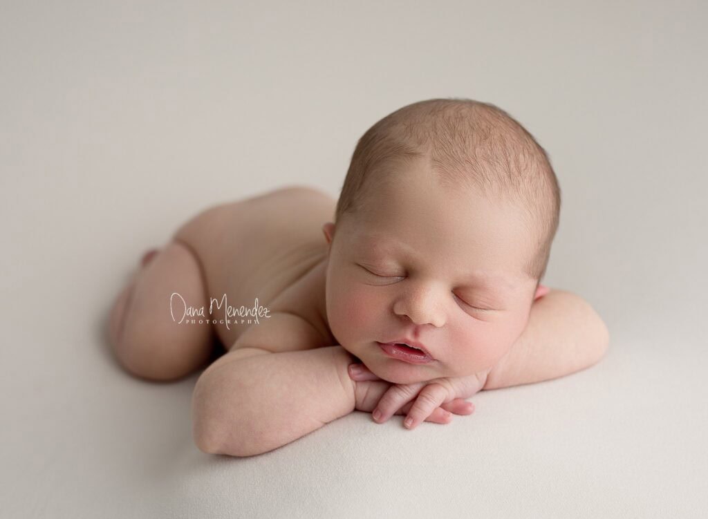 Adorable newborn baby peacefully sleeping on a soft surface.