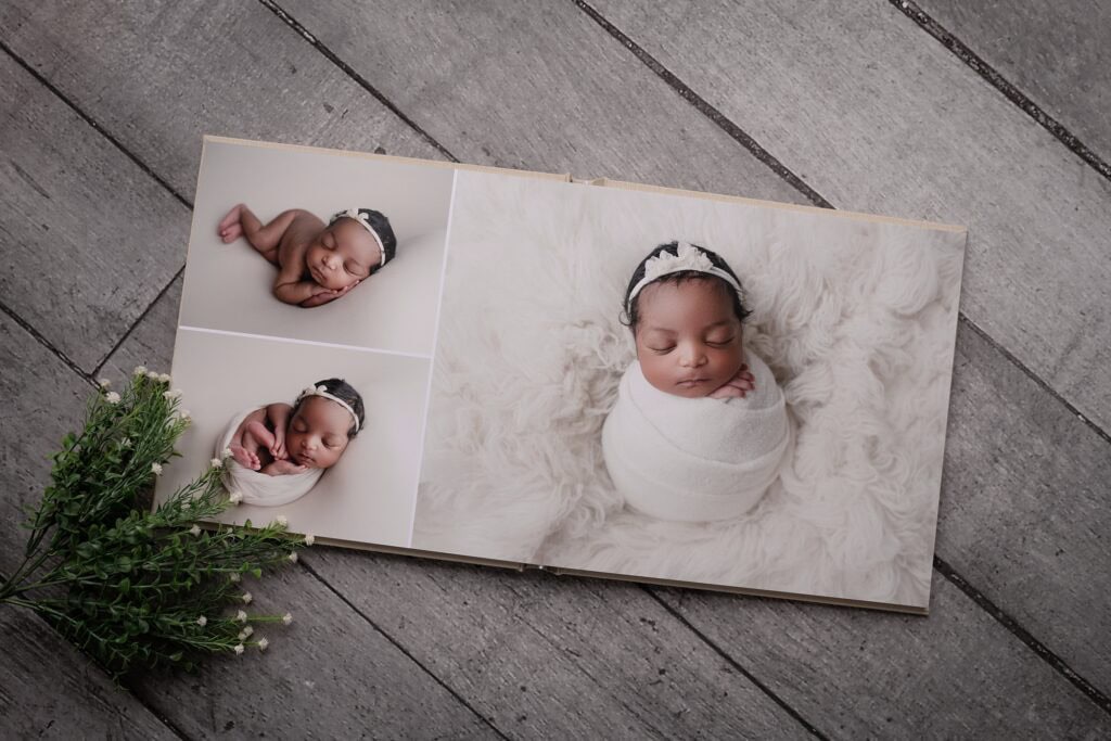Newborn baby wrapped in white blanket, sleeping peacefully in a studio setting.