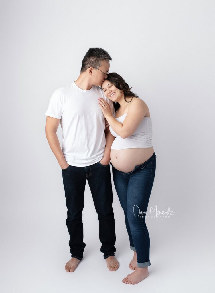 Happy pregnant woman with partner, celebrating pregnancy in studio.