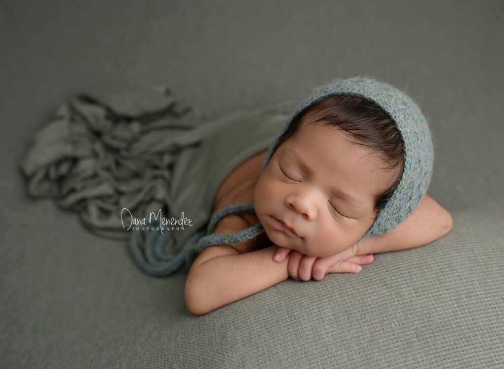 Adorable newborn baby sleeping peacefully with a gray knit hat.