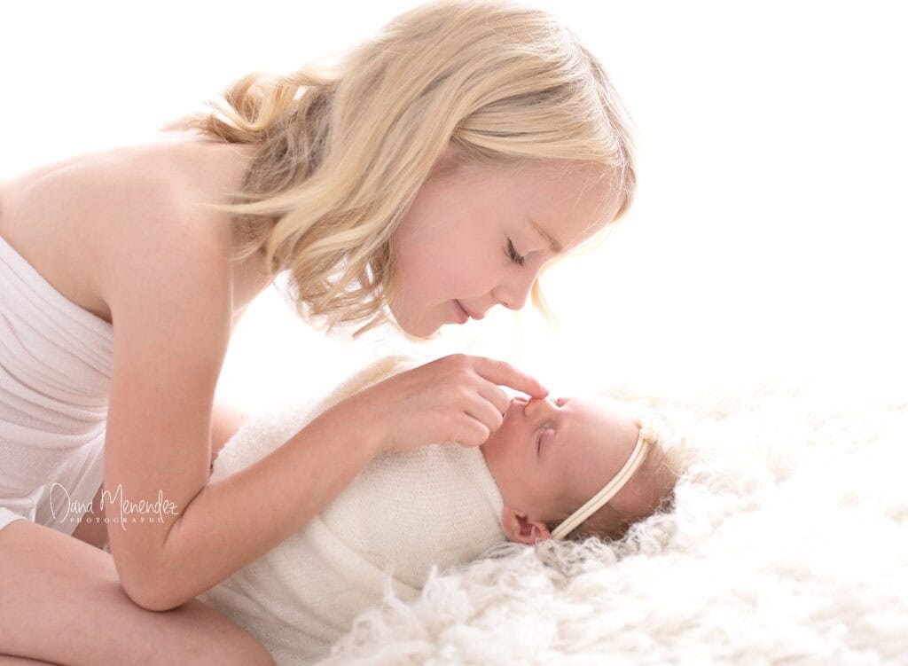 Tender moment between mother and newborn girl, soft lighting, cozy setting.