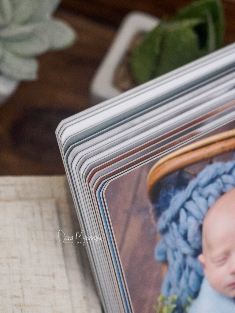 Close-up of a newborn baby in a knitted blue hat, captured by Dana Menendez.