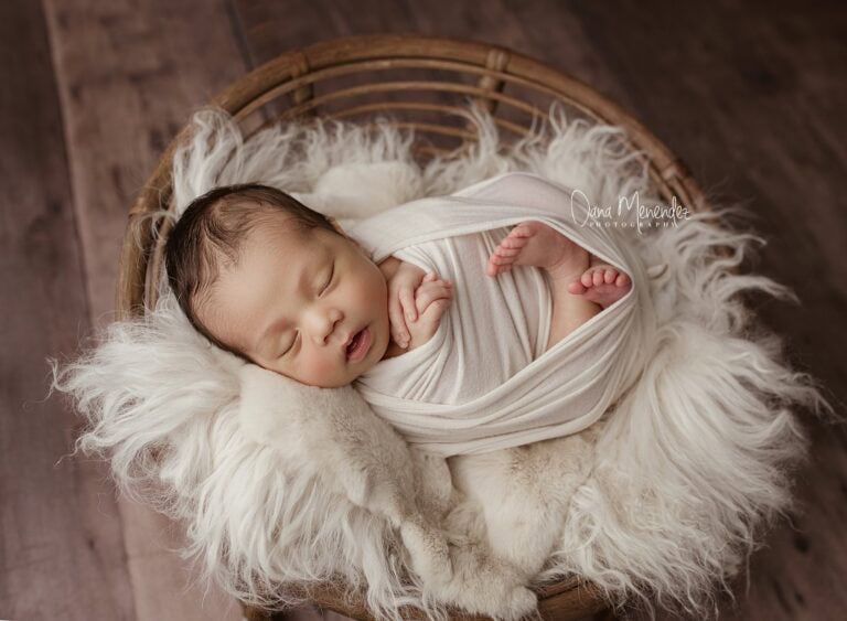 Baby sleeping peacefully in a cozy basket with soft fur lining in Okotoks Alberta
