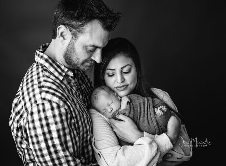 Beautiful black and white image of new parents holding their sleeping baby in Okotoks Alberta