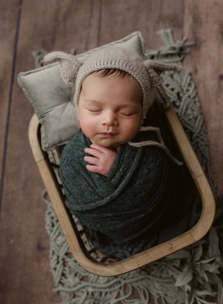 Baby sleeping peacefully in a cozy hat and swaddle.