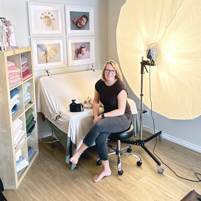 Newborn photographer Dana Menendez in studio with lighting and props.